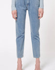 Boyarovskaya Slim Ring Jean. Light color stone denim with a slightly tapered leg and falls to just above the ankle. Zipper closure with silver ring detail on the front right. Product shown on model facing front.