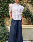 Rochas Paris Cotton Poplin Short Sleeved Shirt. A button up blouse in lightweight cotton it has two front pockets and puffed sleeves. Photo shown on model also wearing Rochas wide leg denim trousers.