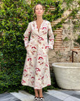 Colville Desert Dress at Experience 27. V neck cotton summer dress in pink and red floral print. Midi length, long sleeves and with a fun hood. Shown on model.