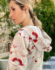 Colville Desert Dress at Experience 27. V neck cotton summer dress in pink and red floral print. Midi length, long sleeves and with a fun hood. Shown on model. Close up of back hood.