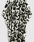 Rochas Paris Fashion Asymmetrical Fluid Top. With a waist length front and a dramatic caped back. Crafted in crepe de chine in a black and white pattern with yellow highlights. This is a product photo from the back.