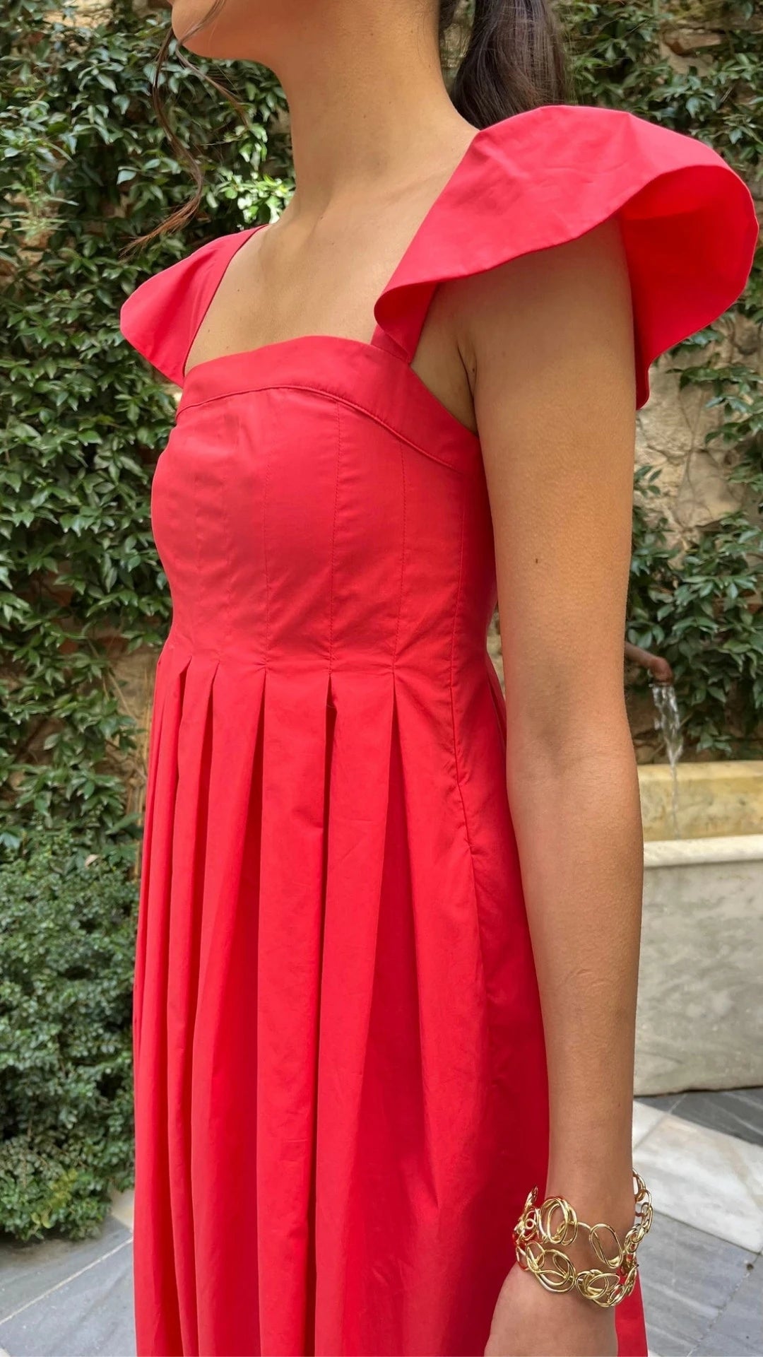 Rochas Paris Empire Waist Cotton Poplin Dress. Sweet with capped sleeves and a square neckline. The fitted body gives way to an a-line skirt. Red cotton poplin summer style. Shown on the model with detail to the cap sleeve.