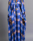 Thebe Magugu Blue Print Belted Kaftan. An elegant draped kaftan dress in blue with soft pink and grey striping. It features a V neck and can be belted to find the perfect fit for your body. It has long sleeves and is floor length. This photo shows the piece on the model facing front.