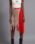 Thebe Magugu Shredded Pleated Skirt. Signature Thebe Magugu pleated skirt but with an asymmetrical twist in ecru, white and red. Shown on model facing forward.