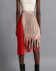 Thebe Magugu Shredded Pleated Skirt. Signature Thebe Magugu pleated skirt but with an asymmetrical twist in ecru, white and red. Shown on model facing back.